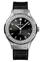 Женские часы Hublot Classic Fusion 565_NX_1470_LR_1204 в титановом корпусе с бриллиантовым рантом, на черном матовом циферблате родиевые часовые метки и стрелки, черная кроко.